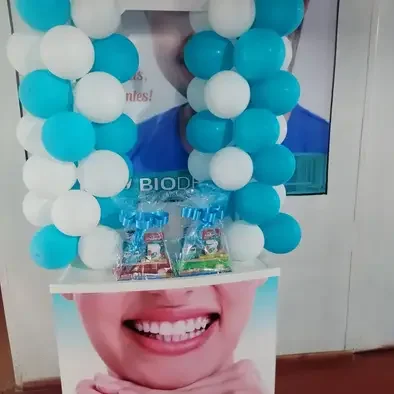 Globos turquesas y blancos decorando el letrero de BioDentist durante un aniversario